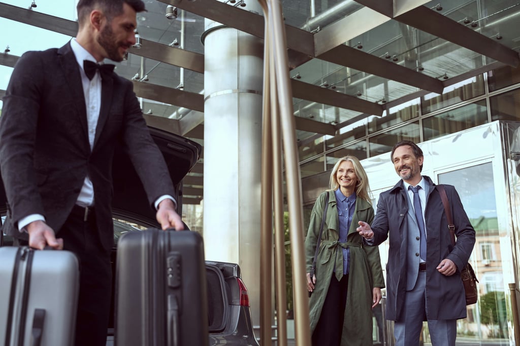 A concierge welcoming residents with luggage outside a building